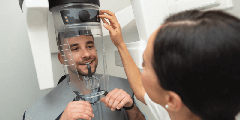 A dental radiography nurse conducting a dental radiograph of a patient